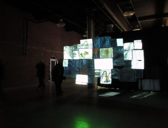 Installation of "Frequency" by Danile Canogar, 2012. 33 analog television screens, projector, multimedia hard drive, 4 min 30 sec animation loop, edition of 3, 118.11 x 78.74 inches. Exhibited by bitforms gallery (NYC). Photo by Pat Rogers. 
