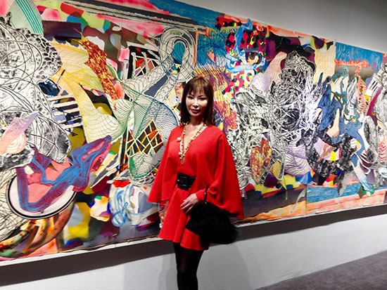 Yung Hee Kim with a collage by Frank Stella in the background at Dominique Levy. Photo by Keming Liu.