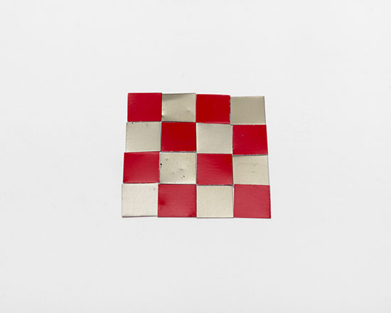 "4 x 4 Al Red & Silver Square" by Carl Andre, 2015. Painted aluminum, 16 elements, each: 1/32 x 5/8 x 5/8 inches, overall: 1/32 x 2 3/4 x 2 3/4 inches. © 2017 Carl Andre / Licensed by VAGA, New York, NY. Courtesy Paula Cooper Gallery, New York. Photo: Steven Probert.