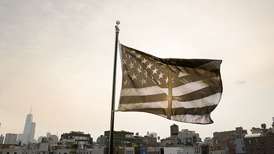 "Untitled (Dividing Time)" by Robert Longo, 2017, installed atop of Creative Time's NYC Headquarters as part of its "Pledges of Allegiance" public art project. Polyester flag. Photo by Guillaume Ziccarelli, Courtesy of Creative Time.
