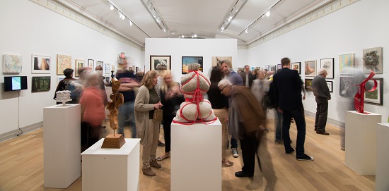 Viewing art on view at Guild Hall's 2018 Artist Members Exhibition. Photo by Ron Esposito. Courtesy of Guild Hall.