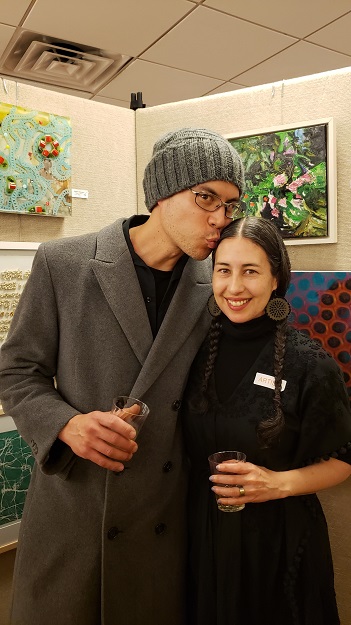Brent Timbol kisses his wife, Darlene Charneco, who has an artwork exhibit at OLA's benefit art sale, during a whimsical moment at the Opening Reception. Photo: Pat Rogers. 