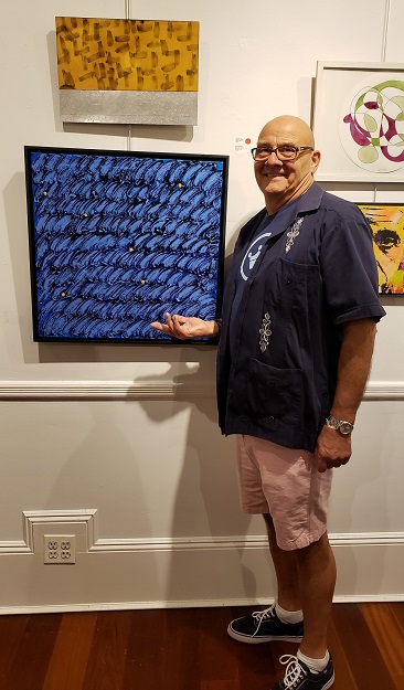 Exhibiting artist Steve Haweeli stands besides his mixed media painting "Blues @ 2:50 pm" at the Opening Reception on Friday, May 24, 2019. Photo: Pat Rogers. 